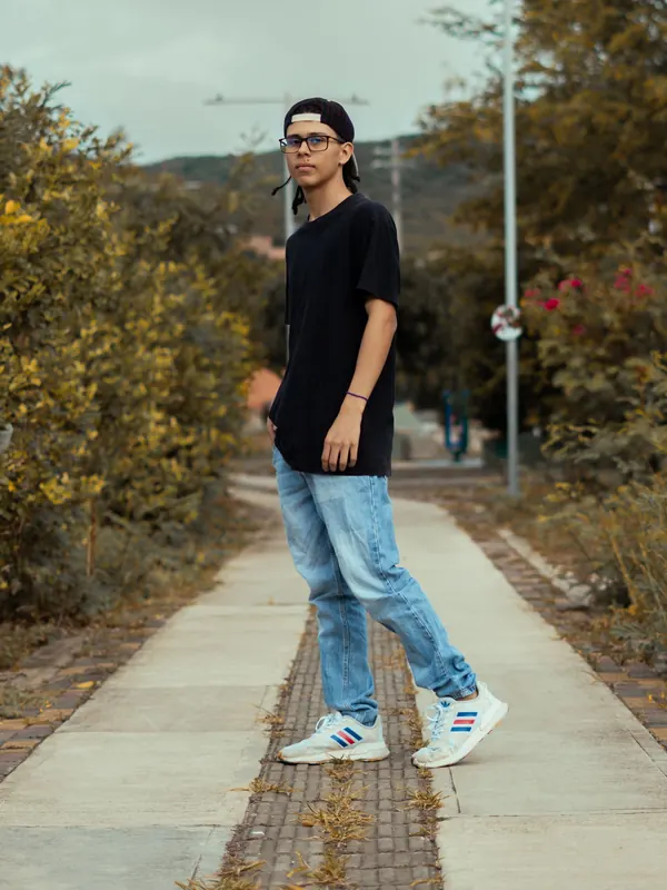 Jeune homme en t-shirt noir et jean slim délavé